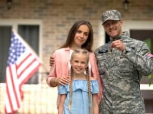 Soldier standing with his wife and daughter